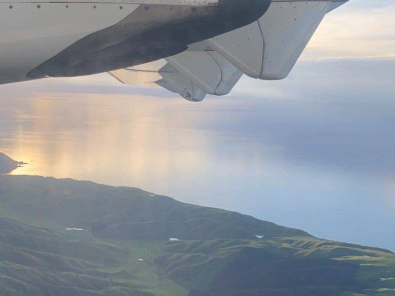 Plane flies over the coast